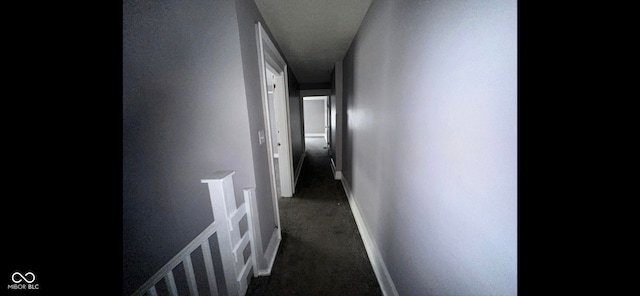 hall with dark colored carpet