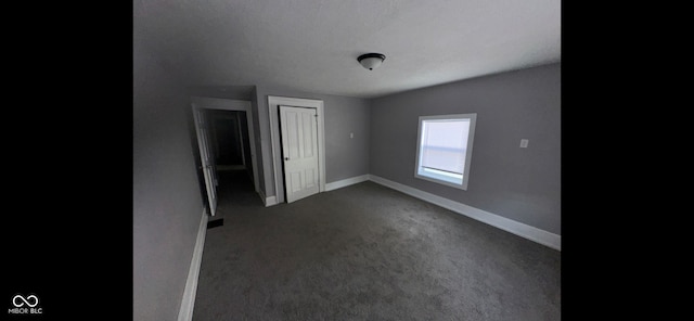 empty room with dark colored carpet