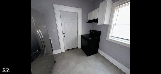 kitchen featuring black range with electric cooktop, white cabinetry, and plenty of natural light