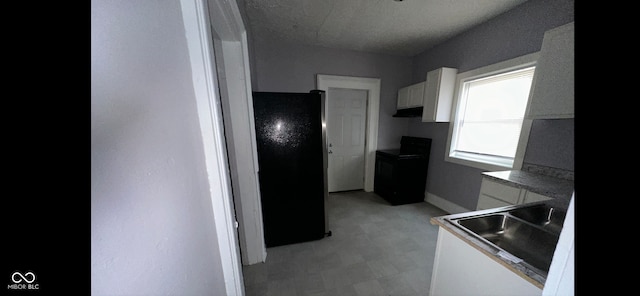 kitchen with white cabinetry, a textured ceiling, black appliances, and sink