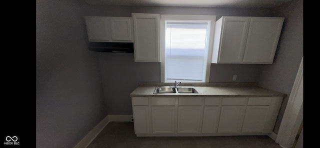 kitchen with white cabinetry, sink, and ventilation hood