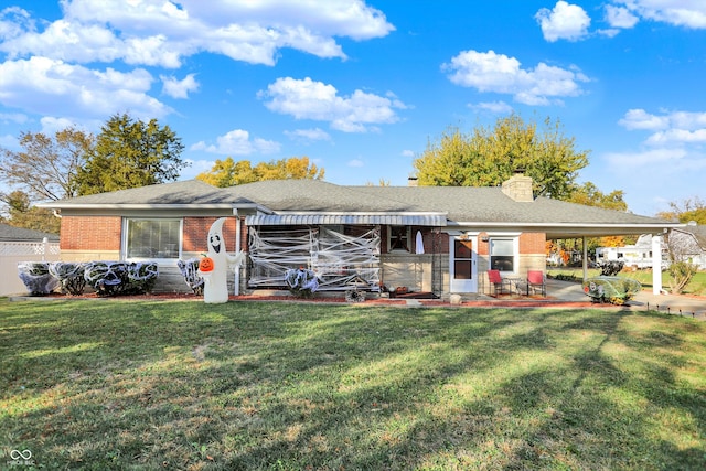 back of house featuring a lawn and a carport