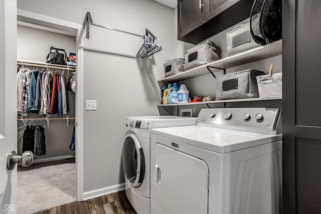 laundry room featuring dark wood-type flooring, washing machine and dryer, and cabinets