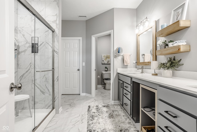 bathroom with toilet, a shower with shower door, and vanity