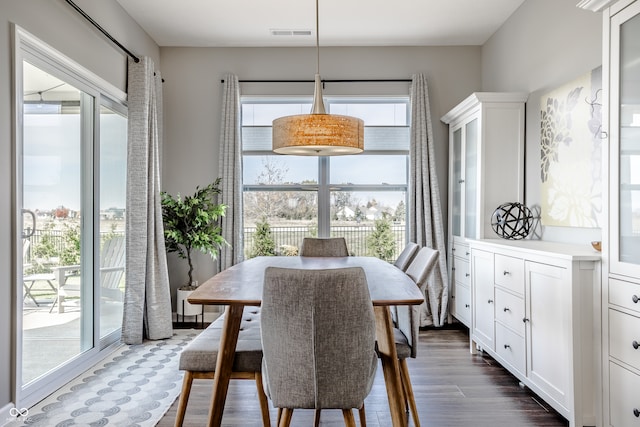 dining area with plenty of natural light and dark hardwood / wood-style flooring