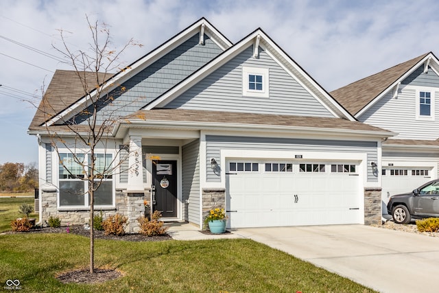 craftsman house with a front yard and a garage