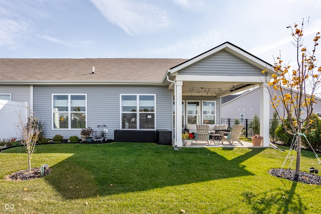 rear view of property with a patio, ceiling fan, and a yard