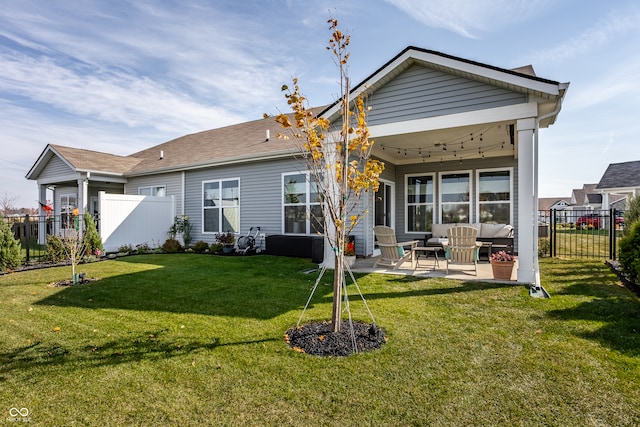 back of house featuring a patio area and a lawn