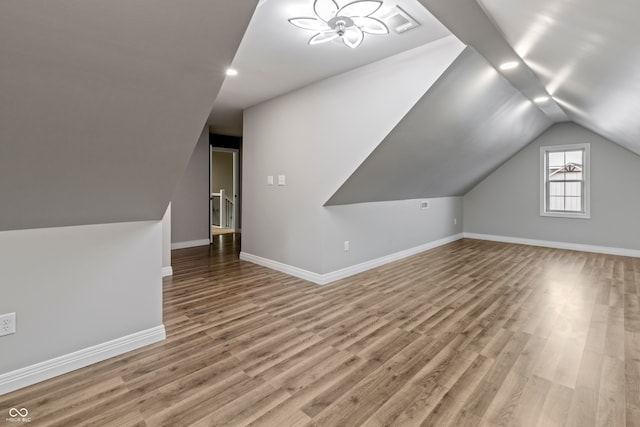 additional living space featuring wood-type flooring, ceiling fan, and lofted ceiling