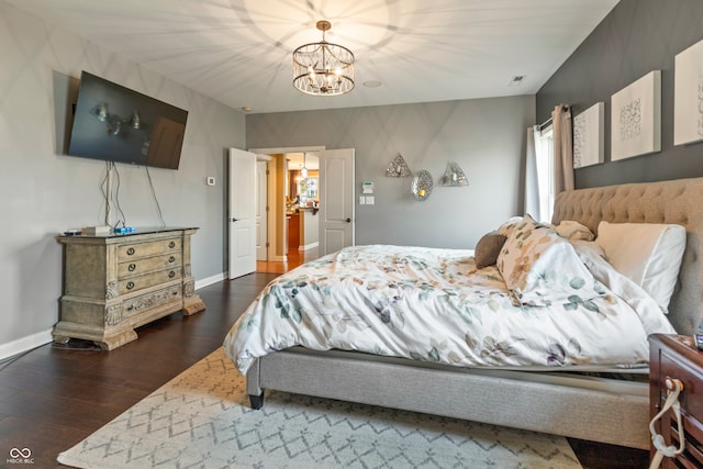 bedroom with dark hardwood / wood-style flooring and a notable chandelier