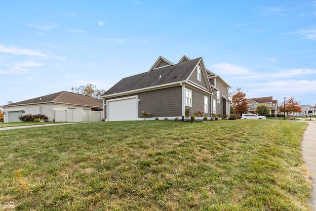 view of side of property featuring a garage and a lawn