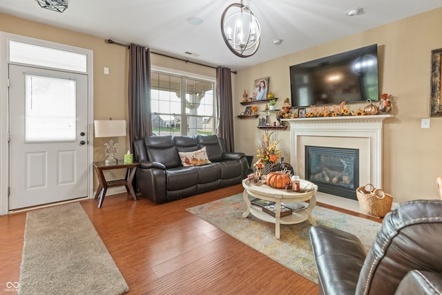 living room with hardwood / wood-style flooring and a notable chandelier