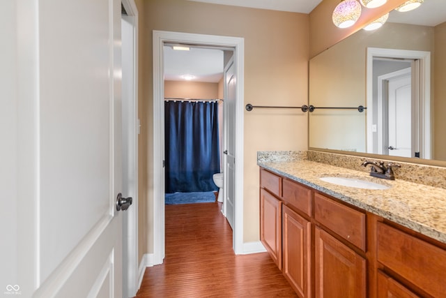 bathroom with toilet, vanity, and hardwood / wood-style floors