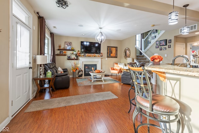 living room with hardwood / wood-style flooring, sink, and an inviting chandelier