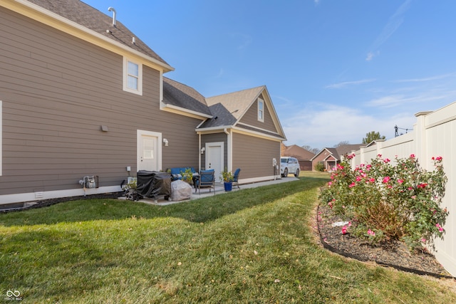 back of house with a lawn and a patio area