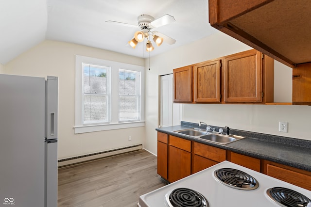 kitchen featuring refrigerator with ice dispenser, white range with electric stovetop, ceiling fan, a baseboard radiator, and sink