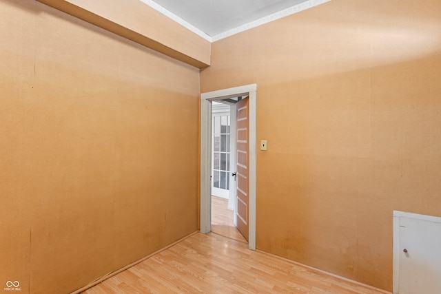 unfurnished room with ornamental molding and wood-type flooring