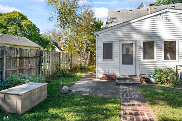 rear view of house with a patio and a yard