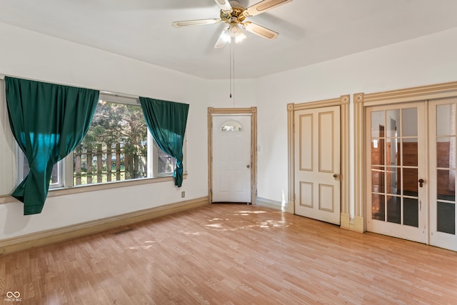 spare room with french doors, ceiling fan, and light wood-type flooring