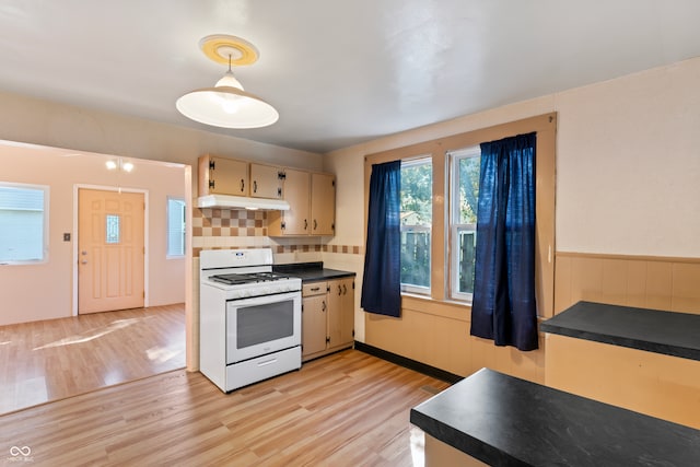 kitchen featuring decorative backsplash, white range with gas cooktop, pendant lighting, and light hardwood / wood-style flooring