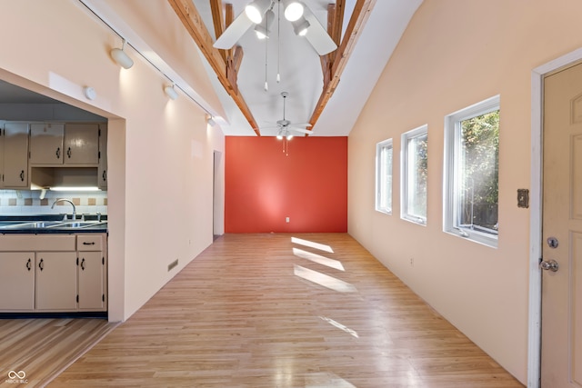 hallway featuring high vaulted ceiling, beam ceiling, light hardwood / wood-style flooring, and sink