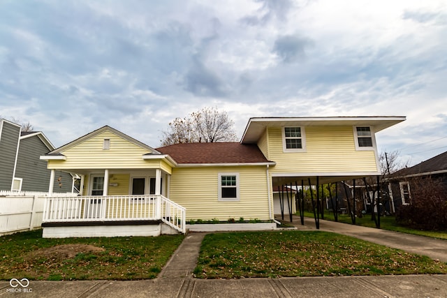 view of front of home featuring a porch, a carport, and a front lawn