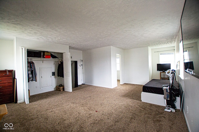 bedroom featuring carpet floors, a textured ceiling, and a closet