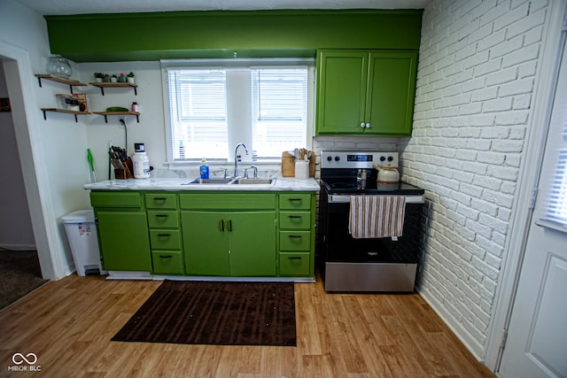 kitchen with stainless steel electric stove, light hardwood / wood-style flooring, sink, and green cabinetry