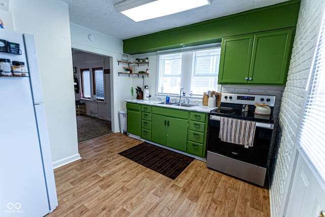 kitchen featuring sink, light hardwood / wood-style flooring, a textured ceiling, white appliances, and green cabinetry