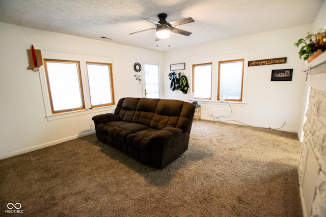 carpeted living room with a textured ceiling and ceiling fan