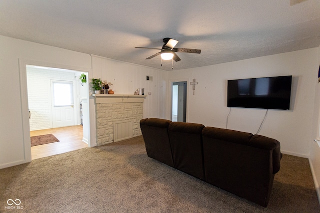 carpeted living room featuring a textured ceiling and ceiling fan