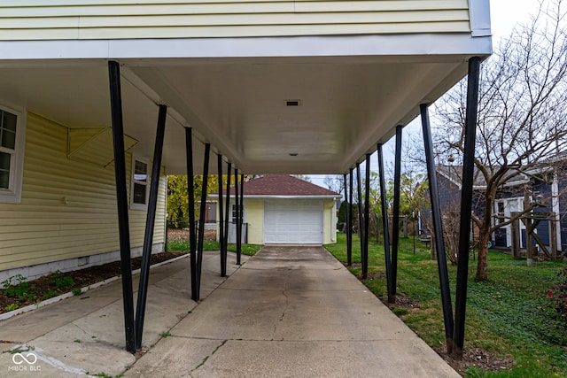 view of patio / terrace featuring a carport, an outdoor structure, and a garage