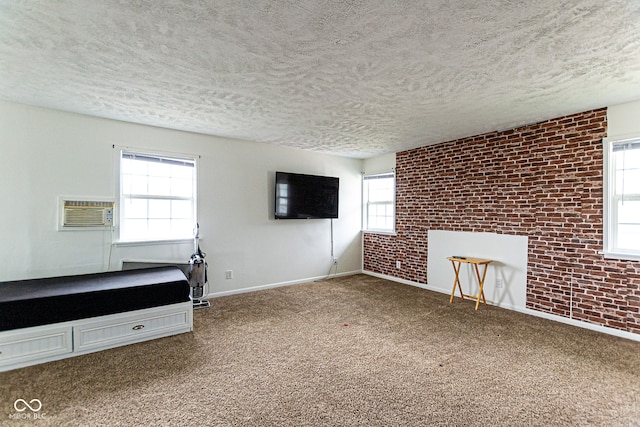 interior space featuring a textured ceiling, brick wall, and a wall mounted AC