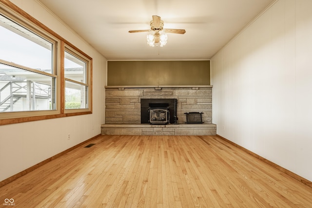 5861 S 100 W, Fountaintown, IN 46130 - unfurnished living room featuring hardwood / wood-style flooring, ceiling fan, a stone fireplace, and ornamental molding