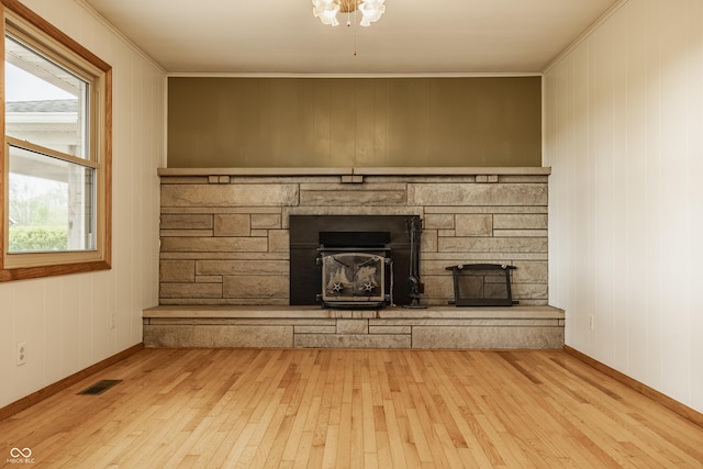 5861 S 100 W, Fountaintown, IN 46130 - unfurnished living room featuring hardwood / wood-style flooring, crown molding, baseboards, a stone fireplace, and wood walls