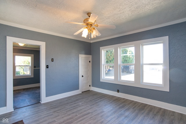 unfurnished room with plenty of natural light, ceiling fan, a textured ceiling, and dark hardwood / wood-style flooring