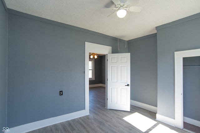 unfurnished bedroom featuring ceiling fan, wood-type flooring, and a textured ceiling