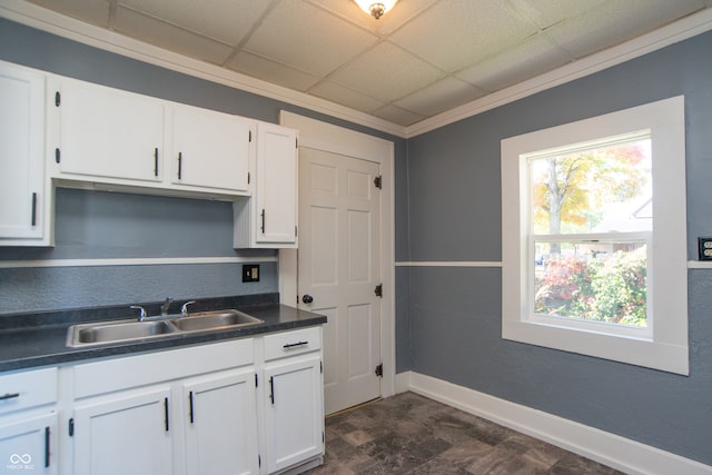 kitchen with ornamental molding, a drop ceiling, white cabinetry, and sink