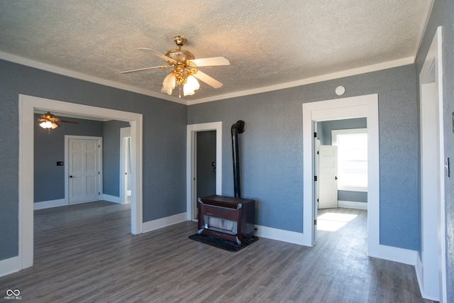 living room with ceiling fan, a wood stove, a textured ceiling, and dark hardwood / wood-style floors