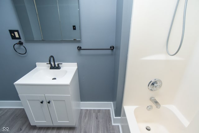 bathroom featuring vanity, hardwood / wood-style flooring, and bathing tub / shower combination