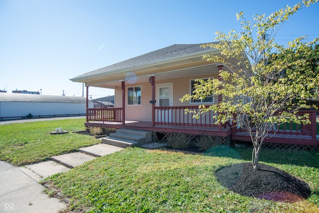 view of front of house with a wooden deck and a front lawn