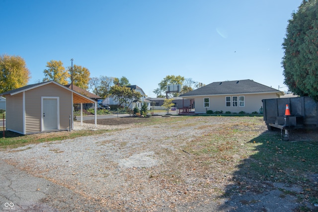 view of yard featuring a carport and a storage unit