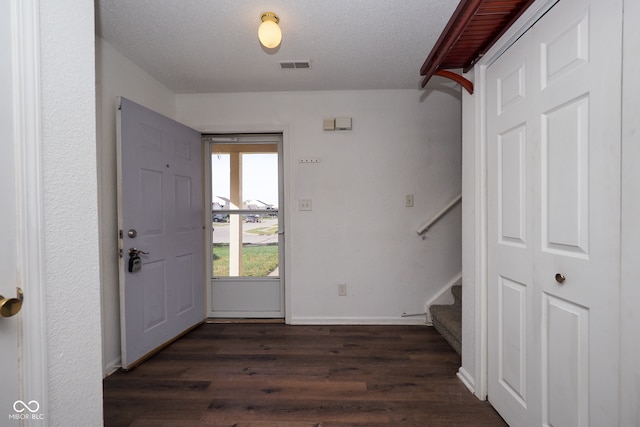 foyer entrance featuring a textured ceiling and dark hardwood / wood-style flooring