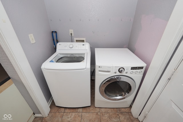 laundry room featuring light tile patterned floors and washing machine and clothes dryer