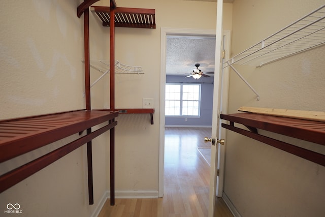 corridor with a textured ceiling and light wood-type flooring