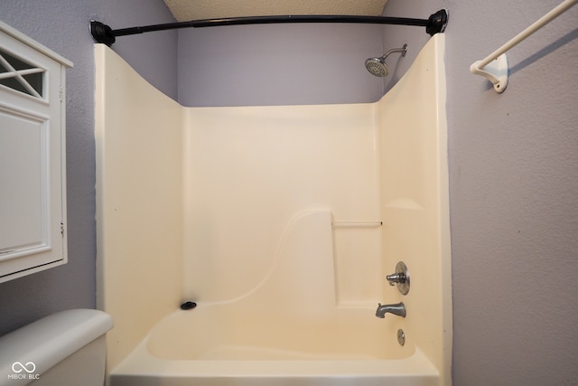 bathroom with toilet and  shower combination