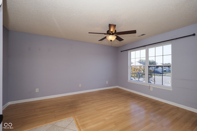 spare room featuring ceiling fan, a textured ceiling, and light hardwood / wood-style flooring