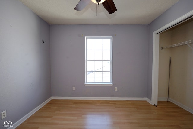 unfurnished bedroom with a closet, ceiling fan, a textured ceiling, and light hardwood / wood-style floors