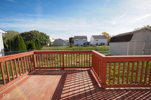 wooden terrace with a shed and a lawn