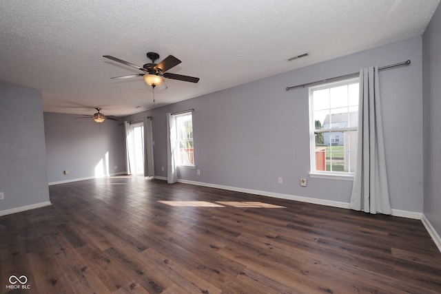 spare room with plenty of natural light, dark wood-type flooring, a textured ceiling, and ceiling fan